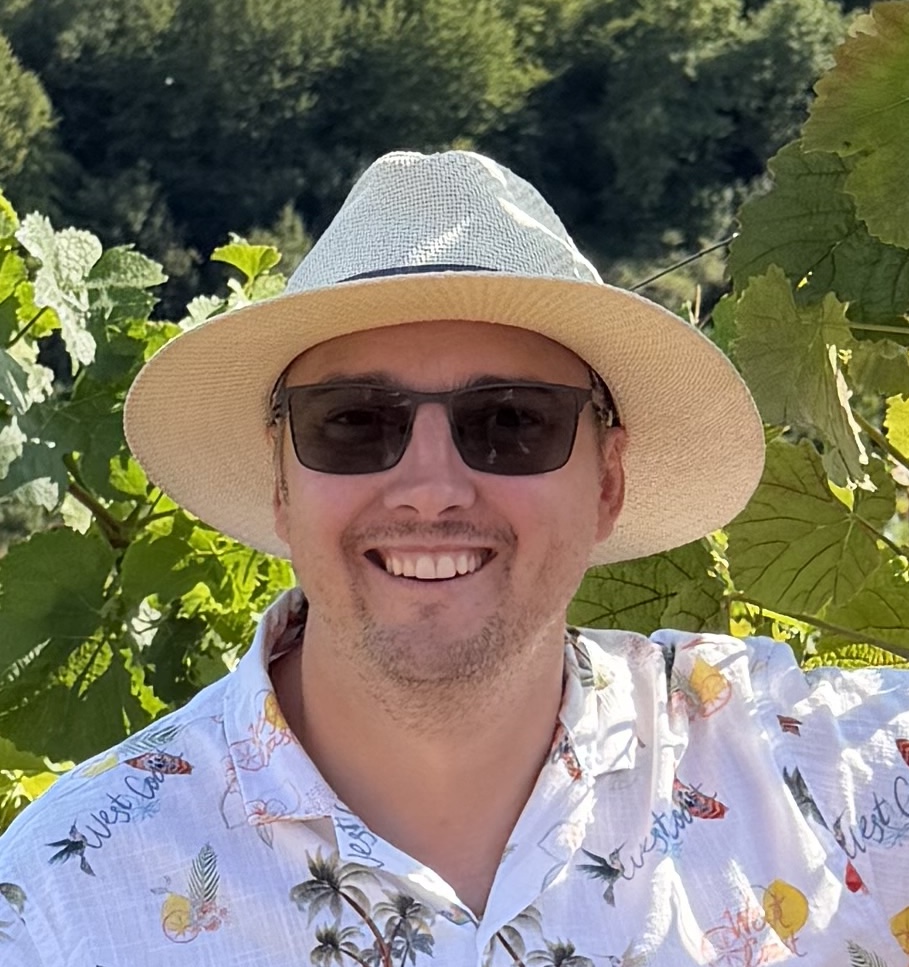 David, wearing sunglasses, a hat and white shirt